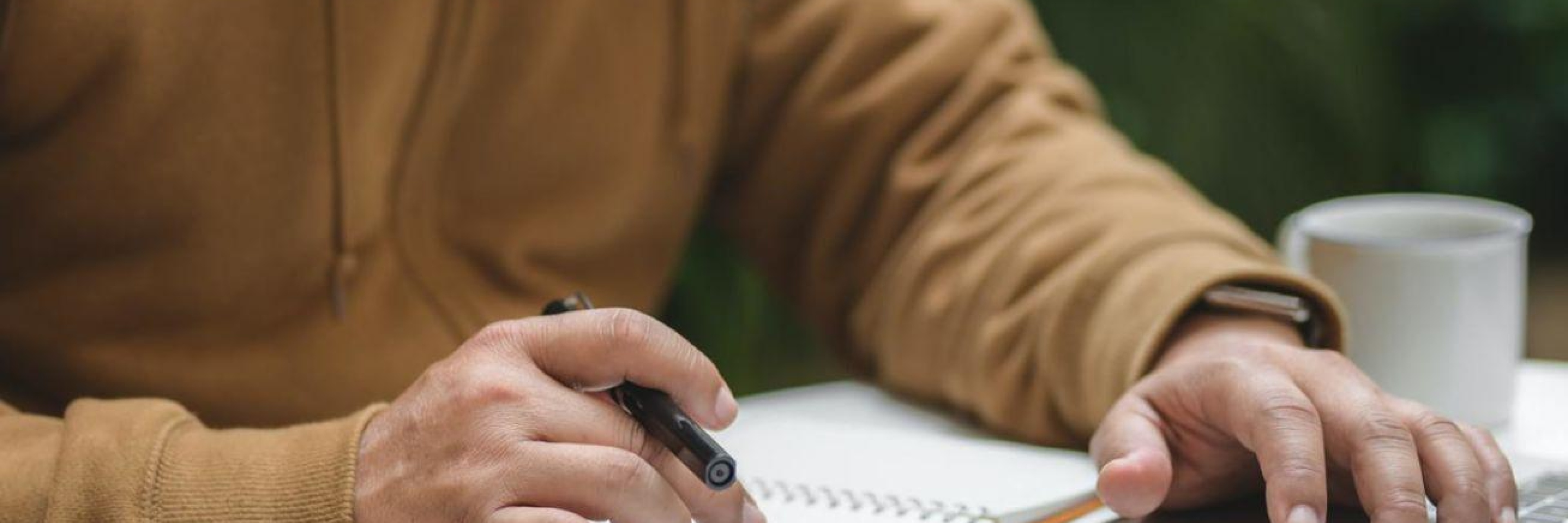Man planning out finances on computer and notebook 3